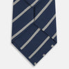View 3 of product The Turnbull & Asser Navy Block Stripe Silk Blend Tie features navy and cream stripes with diagonal light gray accents, displayed against a plain white background.