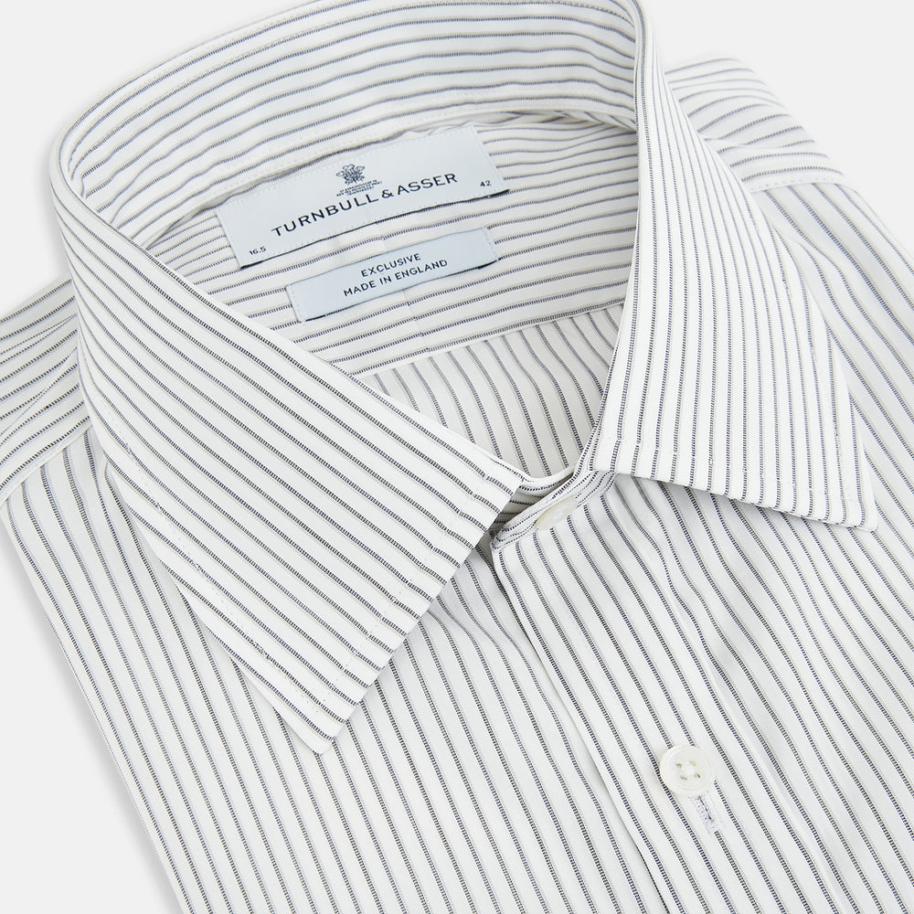The Navy Music Stripe Mayfair Shirt by Turnbull & Asser features thin vertical blue and white stripes, a classic T&A collar, and long sleeves, shown on a plain white background.
