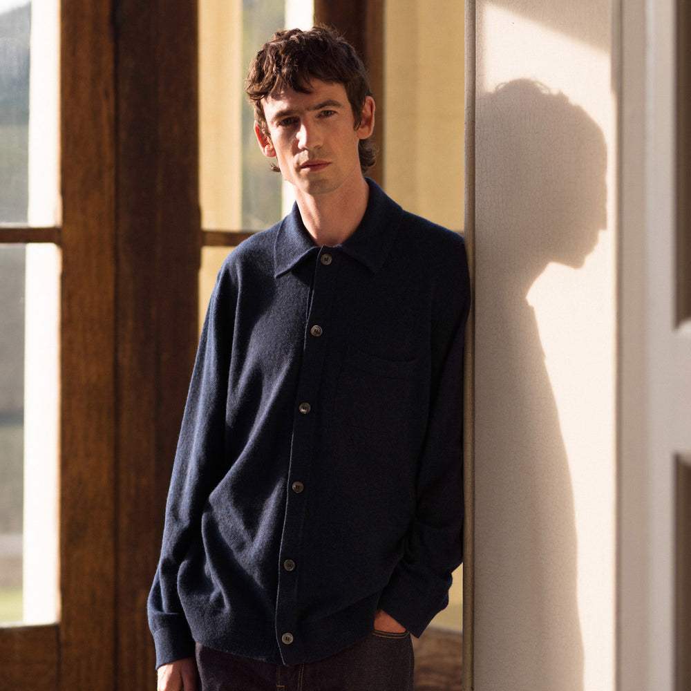 The Turnbull & Asser Navy Cashmere Duncan Knitted Shirt, a button-up with collar, long sleeves, chest pocket, and straight hem, is shown laid flat on a white background.