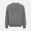 View 3 of product The Turnbull & Asser Grey Melange Cashmere V-neck Jumper features long sleeves, ribbed cuffs and hem, showcasing timeless style against a white background.