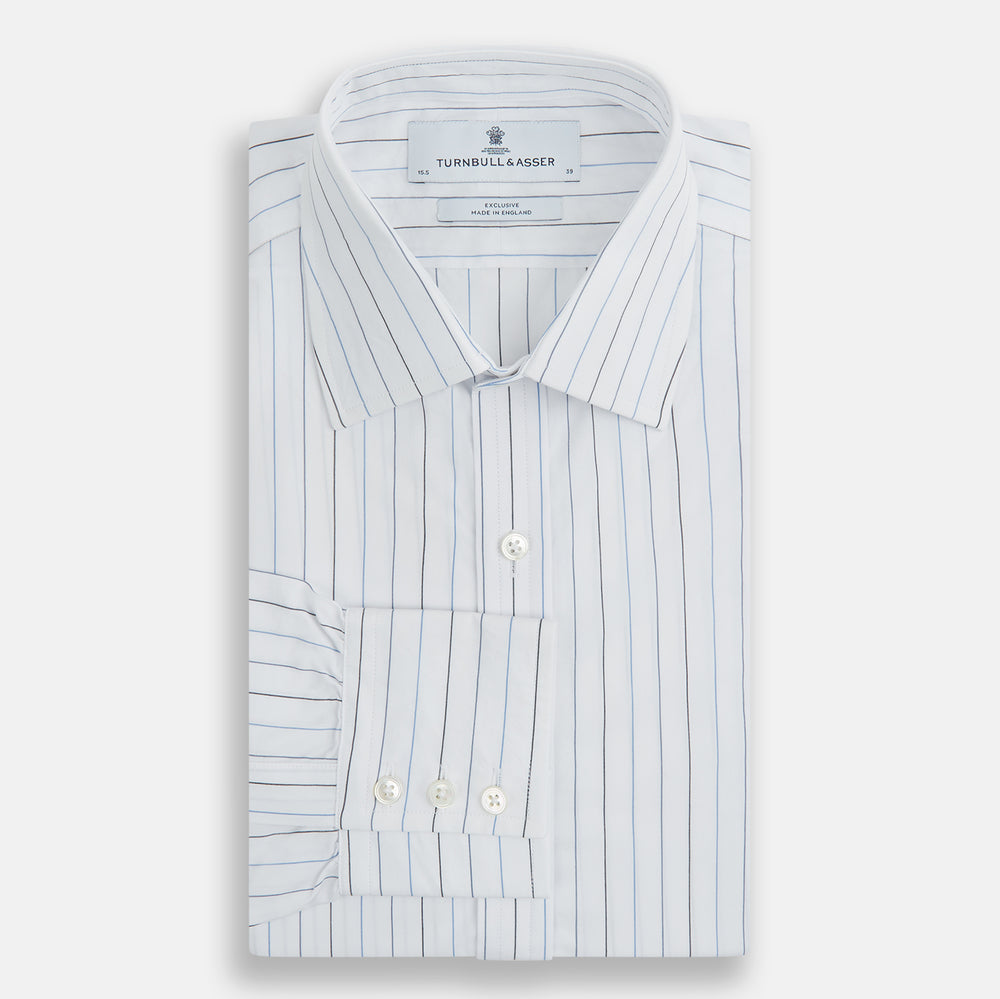 The Blue Wide Pinstripe Mayfair Shirt by Turnbull & Asser is a contemporary long-sleeve button-down with a collar, crafted from white fabric with bold vertical blue pinstripes. It is displayed neatly on a plain white background.