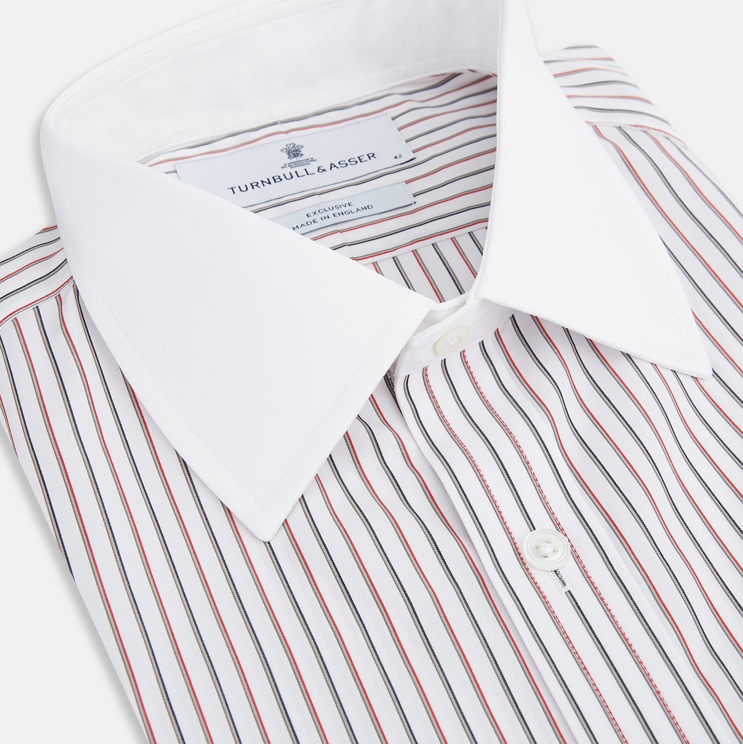 View 2 of product The Red Double Stripe Shirt with contrast T&A collar and cuffs by Turnbull & Asser features classic thin vertical red stripes and solid white collar and cuffs, laid flat on a white background for a timeless look.