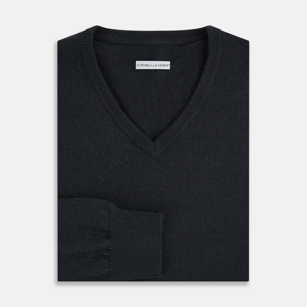 The Turnbull & Asser Dark Green Cashmere V-Neck Jumper features long sleeves, ribbed cuffs, and a ribbed waistband, showcased against a white background.