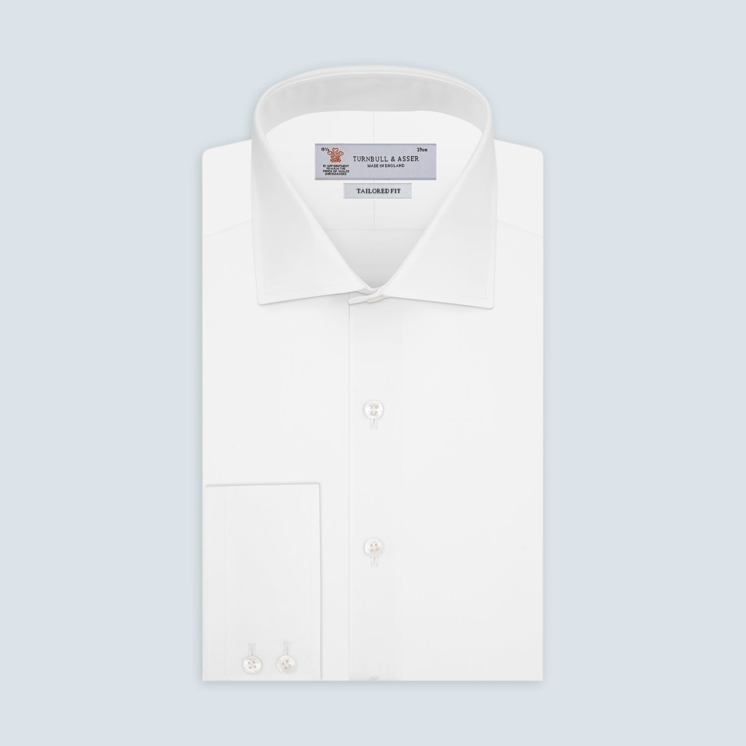 View 1 of product A Turnbull & Asser Tailored Fit Two-Fold 120 White Cotton Shirt with a Kent collar and 2-button cuffs is neatly folded against a light blue background, displaying the brand label inside the collar.