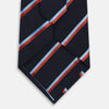 View 3 of product The Turnbull & Asser Red And Blue Stripe Silk Blend Tie, rolled on a white background, features refined diagonal accents—an elegant formal accessory.