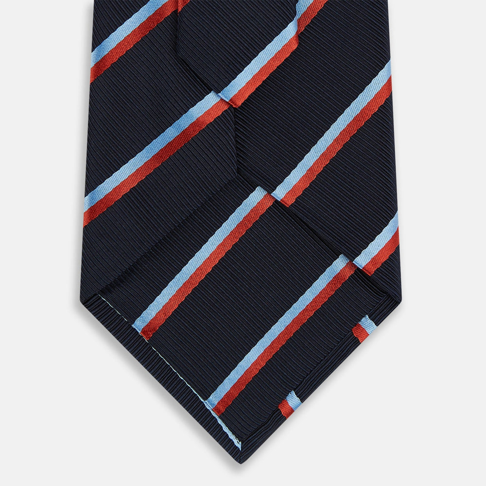 The Turnbull & Asser Red And Blue Stripe Silk Blend Tie, rolled on a white background, features refined diagonal accents—an elegant formal accessory.