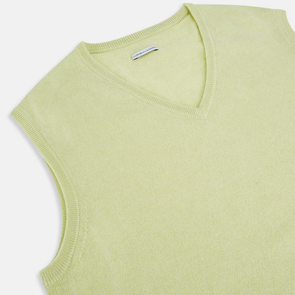 The Turnbull & Asser Melon Green V-neck Cashmere Vest features a ribbed hem and sleeveless design, ideal for a distinguished look. Presented against a plain white background.