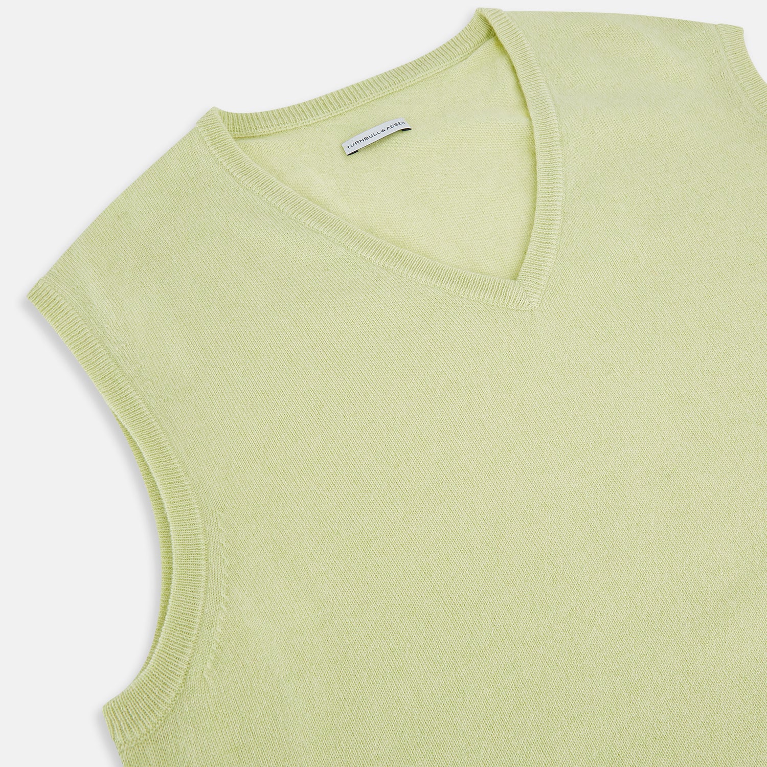 View 2 of product The Turnbull & Asser Melon Green V-neck Cashmere Vest features a ribbed hem and sleeveless design, ideal for a distinguished look. Presented against a plain white background.