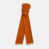 View 1 of product The Orange Cashmere Scarf by Turnbull & Asser features a soft texture, fringed edges, and a rich orange hue—an elegant luxury accessory displayed on a white background.