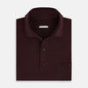 View 4 of product The Turnbull & Asser Burgundy Polo Shirt is crafted from soft cotton jersey with short sleeves, a classic collar, three front buttons, and a small buttoned chest pocket, shown flat on a white background.