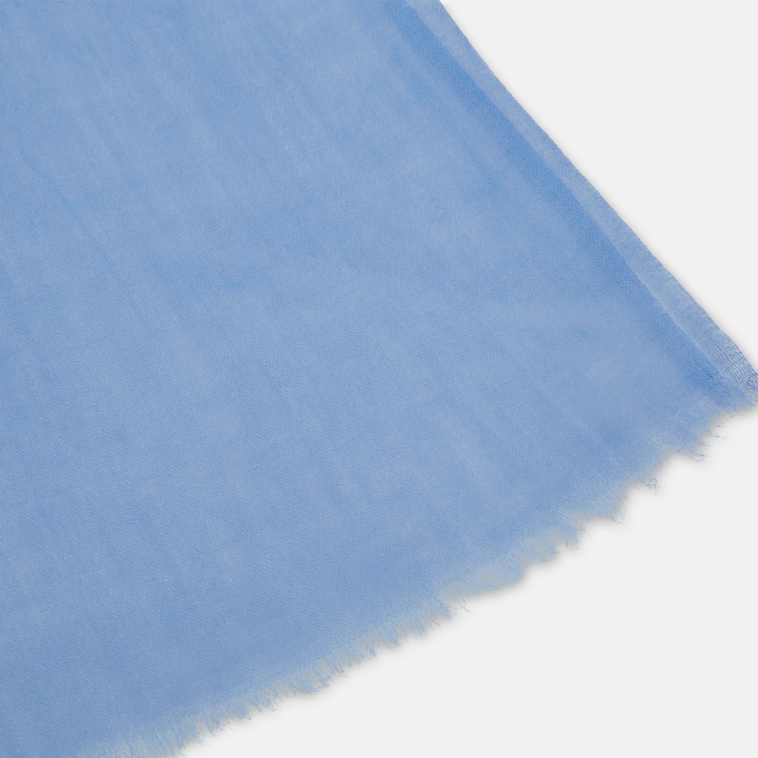 View 2 of product The Azzurro Cashmere Scarf by Turnbull & Asser is shown in light blue, hand-dyed cashmere, semi-sheer and loosely knotted, displayed against a plain white background.