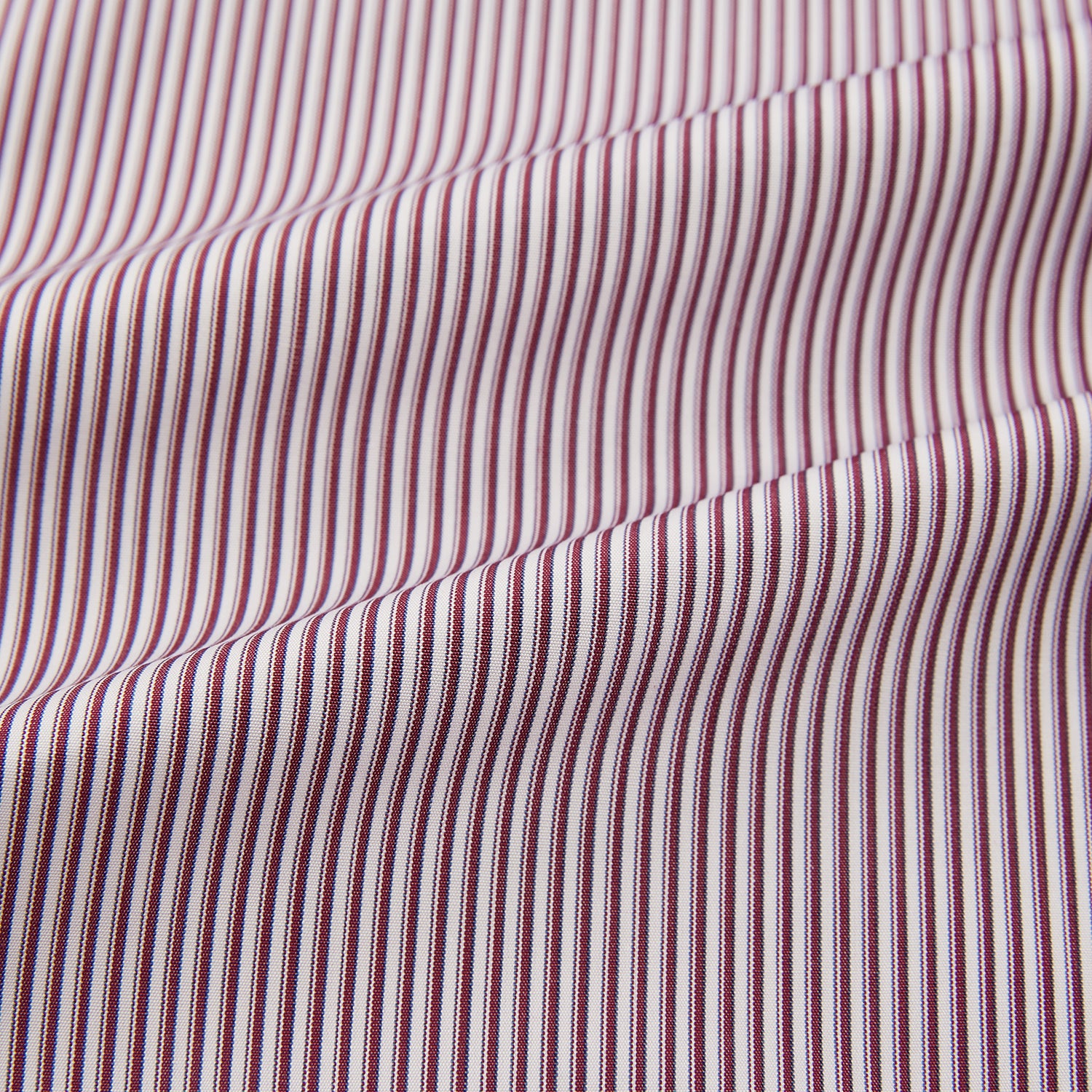 View 6 of product The Turnbull & Asser Burgundy Shadow Stripe Mayfair Shirt is a long-sleeved button-up with thin vertical burgundy stripes, classic collar, and buttoned cuffs, shown laid flat on a white background.