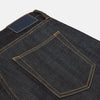 View 3 of product A pair of Turnbull & Asser Indigo Japanese Selvedge Denim Jeans in dark blue with rolled-up cuffs, yellow stitching, five pockets, and a button fly, laid flat on a white background.