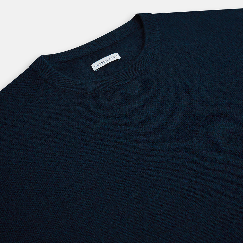 The Turnbull & Asser Navy Cashmere Round Neck Jumper for men is shown against a white background, featuring long sleeves, a relaxed fit, and ribbed cuffs, hem, and collar for an effortlessly elegant look.