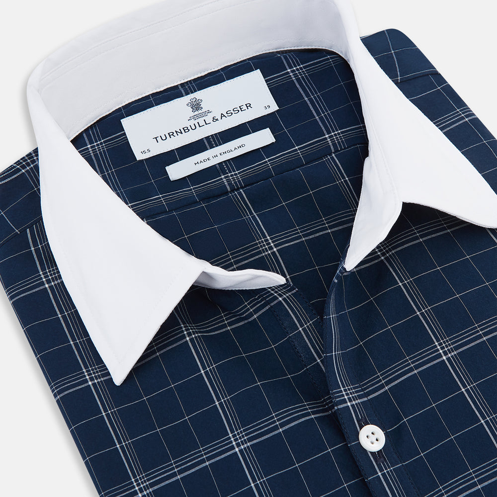 The Turnbull & Asser Indigo Windowpane Check Windsor Shirt features a contrast T&A collar and cuffs, highlighting British craftsmanship. It is displayed flat on a white background.