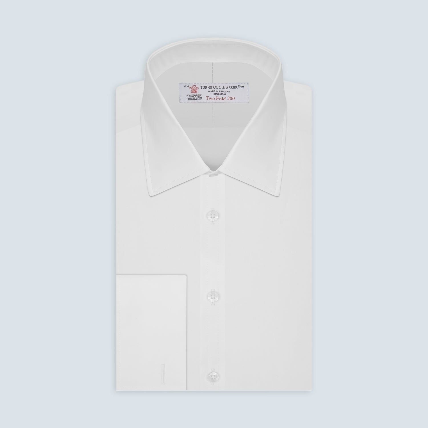 View 1 of product A Turnbull & Asser Two-Fold 200 White Cotton Shirt with T&A collar and double cuffs, neatly folded to show the label inside the collar, is displayed on a light blue background.