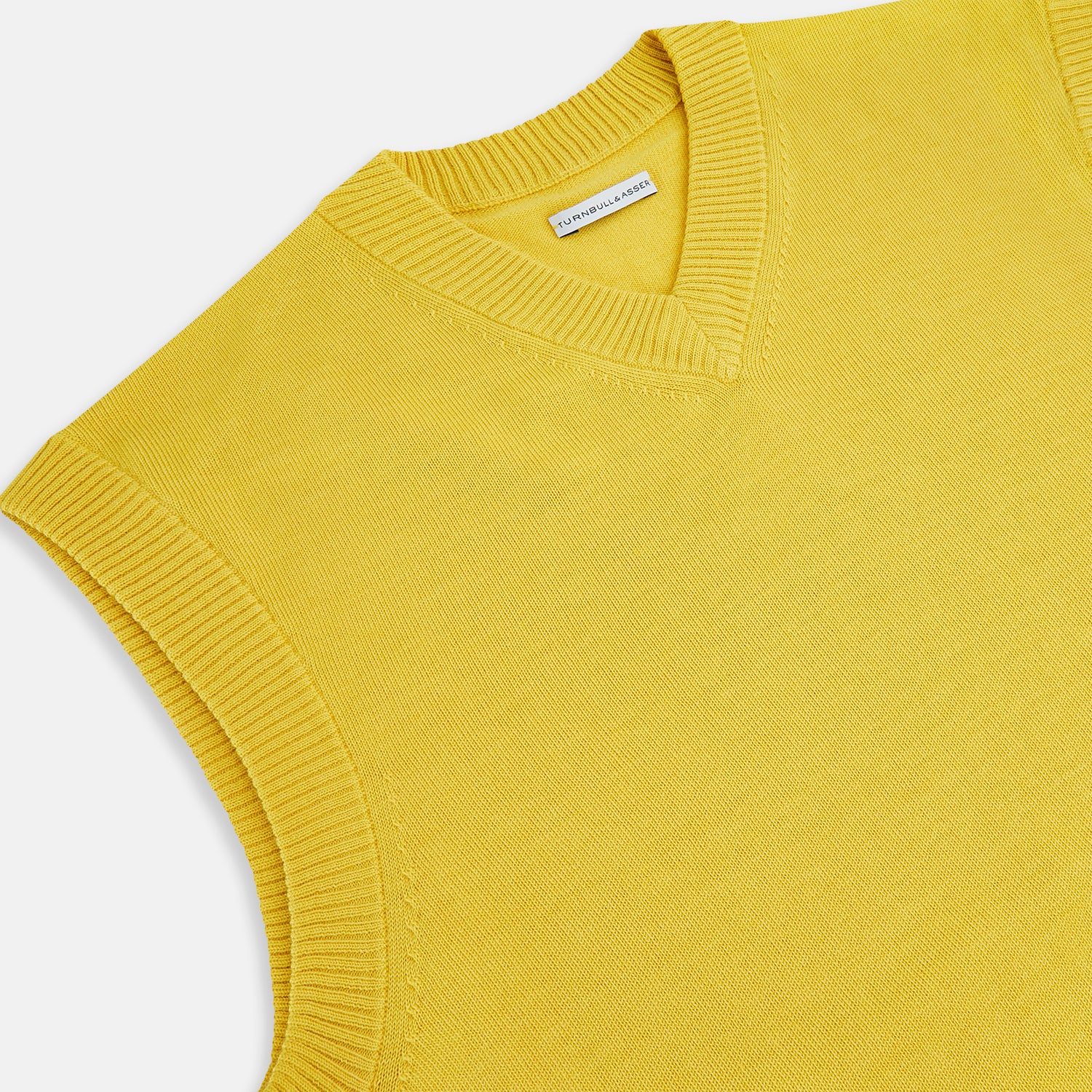 View 2 of product The Turnbull & Asser Canary Yellow Fine Merino V-Neck Vest is a sleeveless knit sweater with ribbed trim, adding elegance to any gentleman's outfit. Shown here on a plain white background.