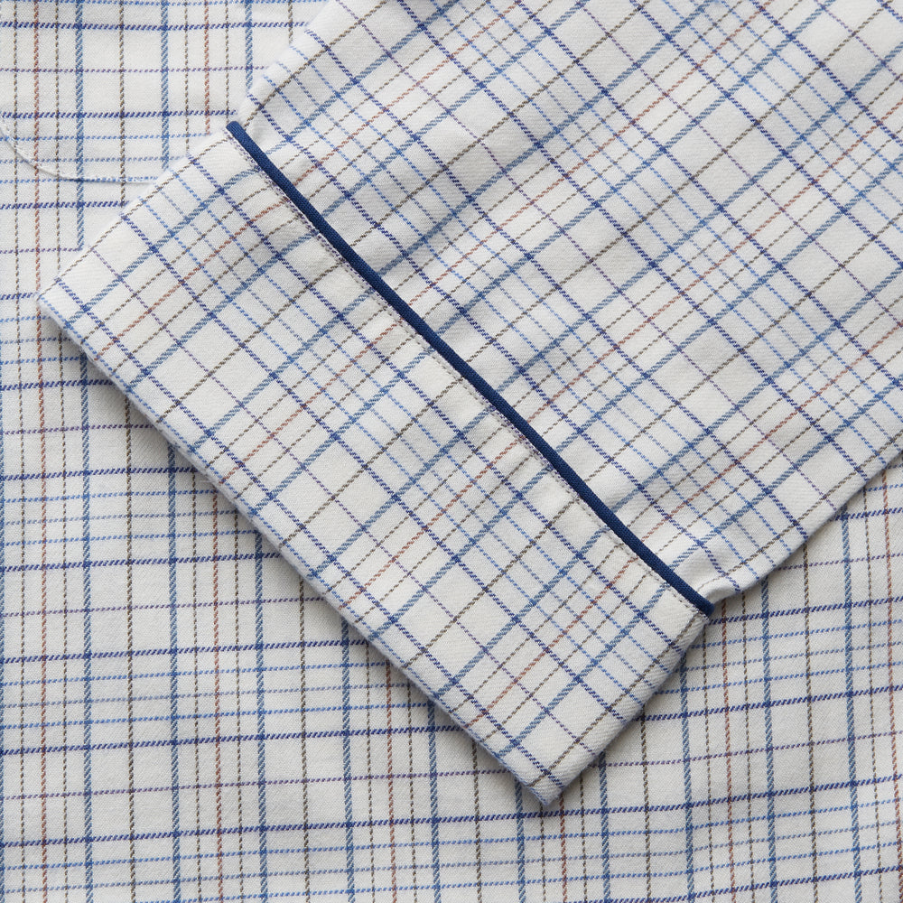 The Turnbull & Asser Blue Multi Check Cotton-Cashmere Modern Pyjama Set features a two-piece design with a long-sleeve button-up top with breast pocket and matching elastic-waist pants in a blue and white check pattern.