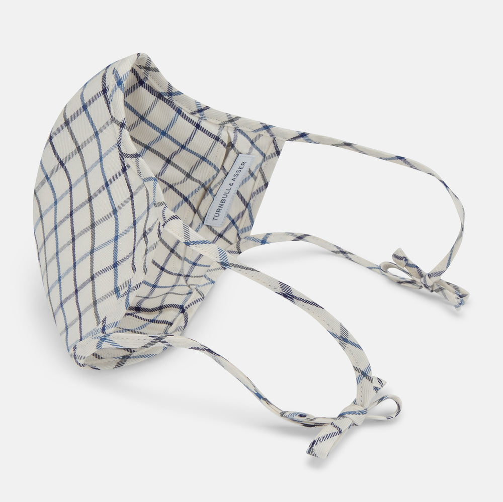 The Turnbull & Asser Check Blue Multi Commuter Mask features a blue plaid design, adjustable fabric ear loops tied in bows, and comes with 3 Viroformula™ filters. Laid flat on a white background.