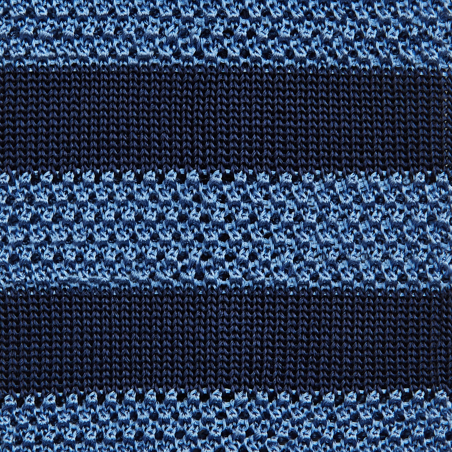 View 3 of product The Turnbull & Asser Navy and Blue Square tipped knitted tie features horizontal stripes and a rolled-up silk design, elegantly displayed on a plain white background.