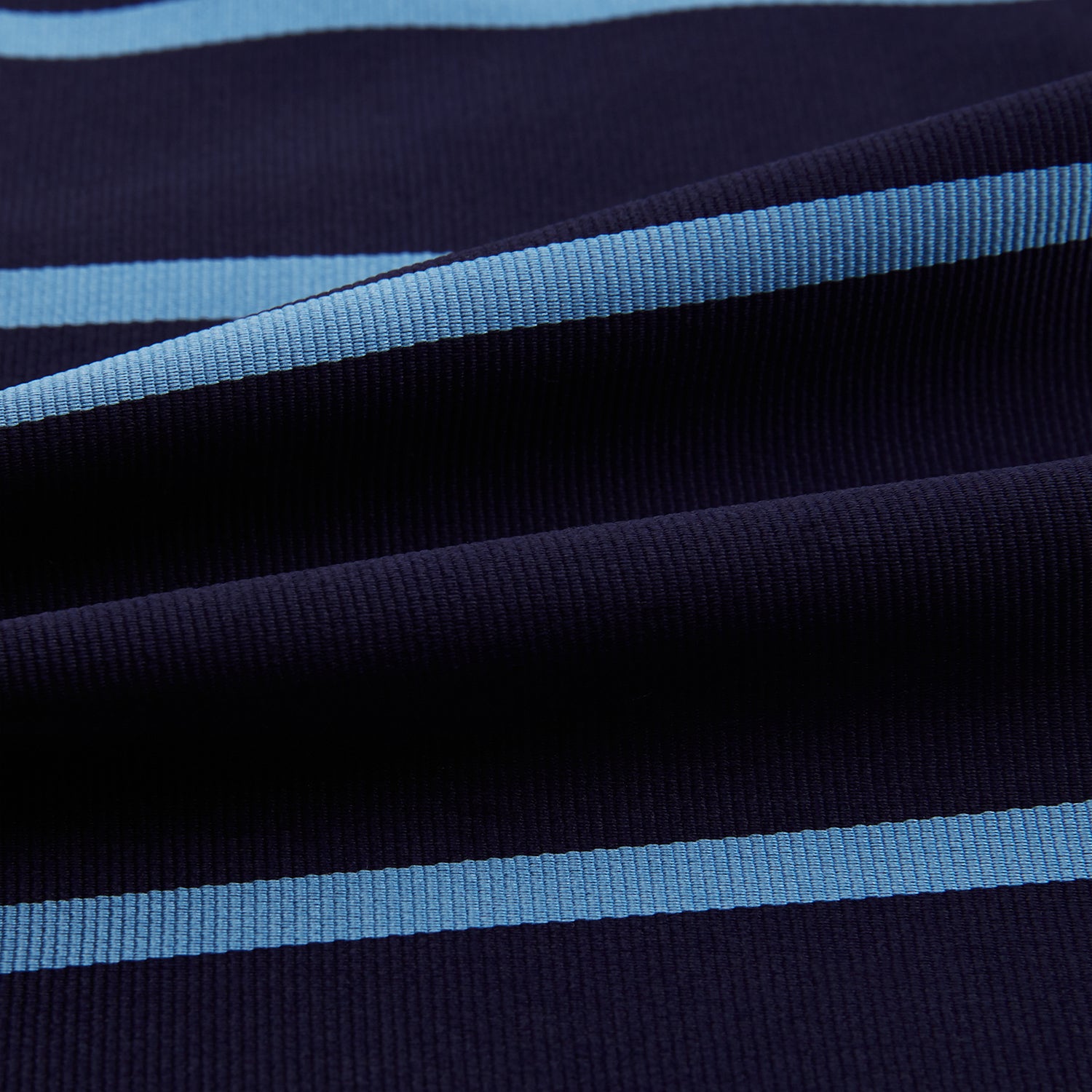 View 4 of product The Turnbull & Asser Azzurro Stripe and Navy Silk Cravat is elegantly displayed against a white background, featuring two horizontal light blue stripes and a bottom edge forming a downward-pointing triangle.
