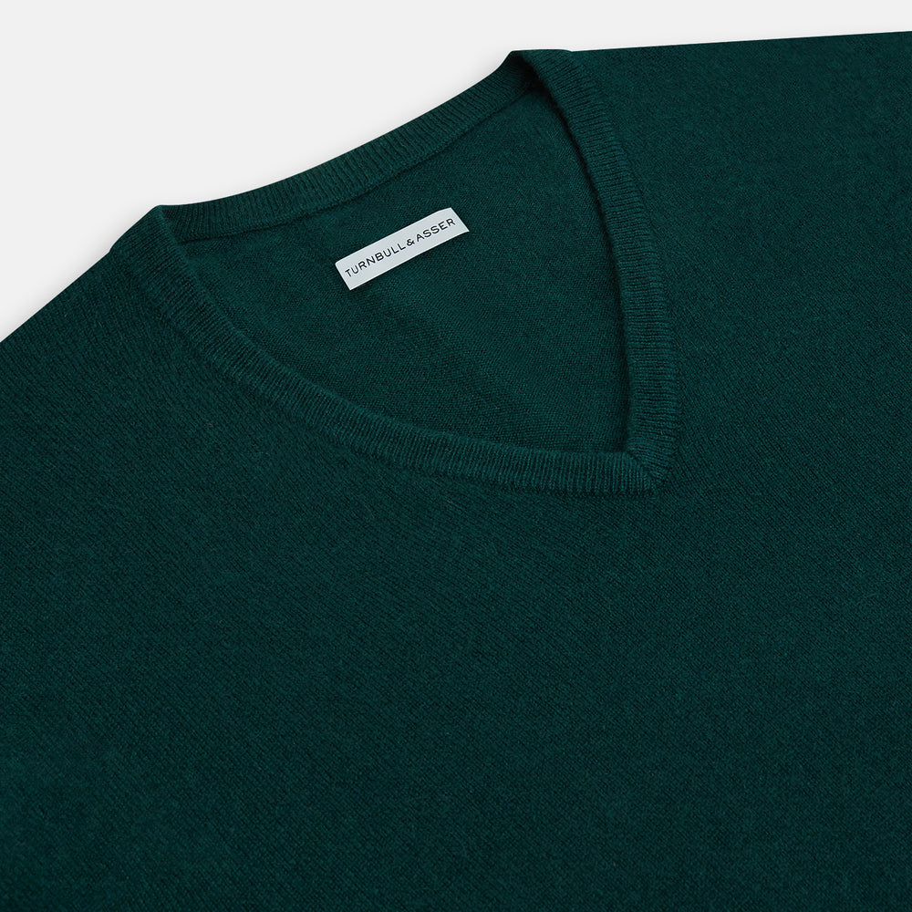 The Turnbull & Asser Forest Green Cashmere V-neck Jumper features ribbed cuffs and hem, shown against a white background—an essential knitwear staple for any wardrobe.