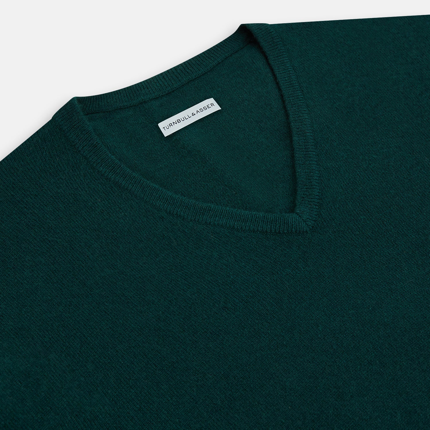 View 2 of product The Turnbull & Asser Forest Green Cashmere V-neck Jumper features ribbed cuffs and hem, shown against a white background—an essential knitwear staple for any wardrobe.