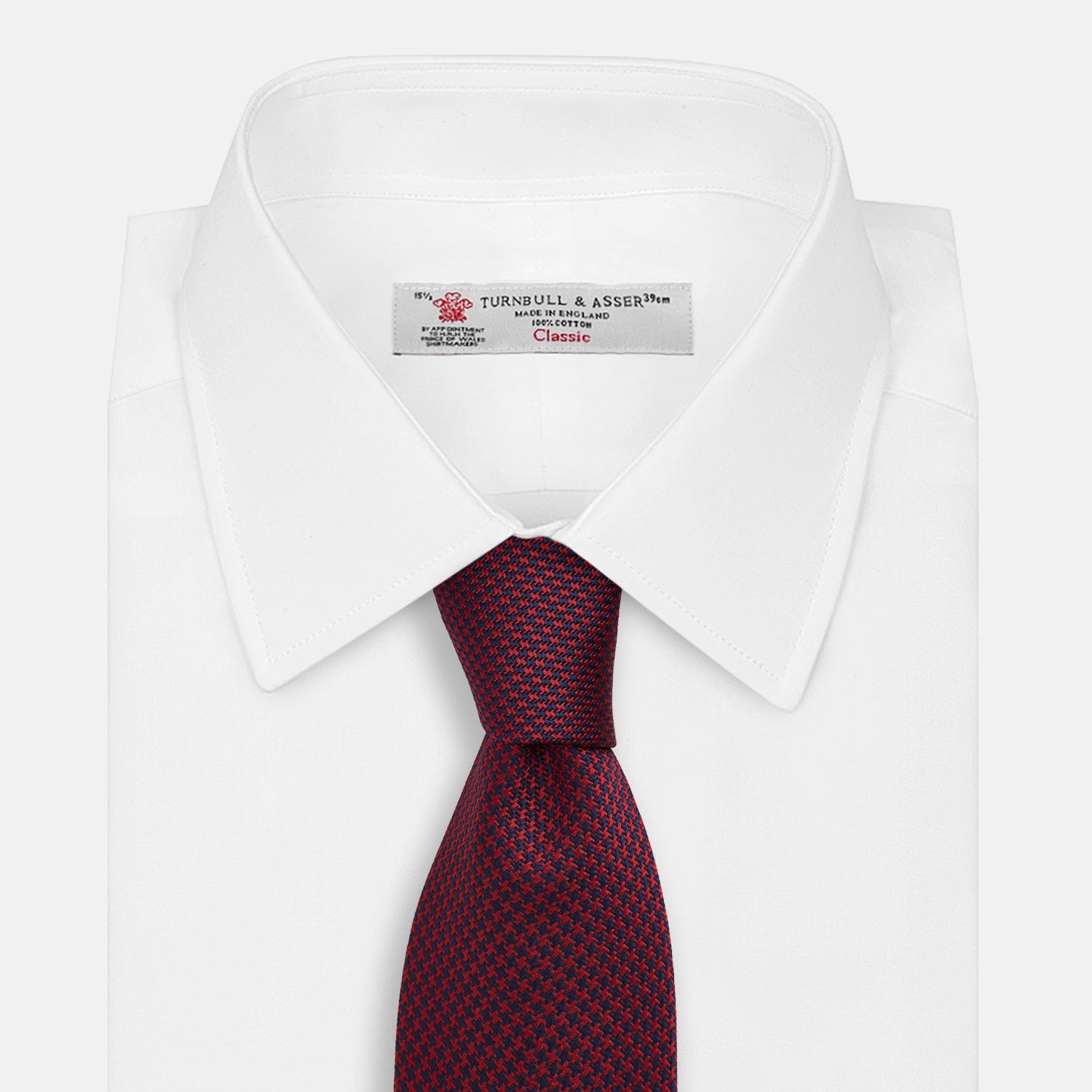 View 2 of product The HOUNDSTOOTH NAVY BURGUNDY TIE by Turnbull & Asser features a textured navy and burgundy silk woven pattern—an elegant staple for every gentleman’s wardrobe.