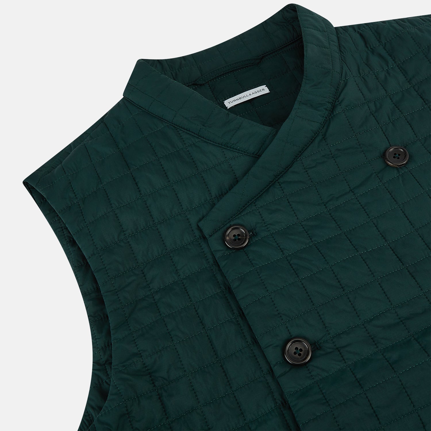 View 2 of product The Turnbull & Asser Forest Green Double-Breasted Quilted Gilet features black buttons, a chest pocket, two zippered side pockets, and an overlapping collar—ideal for layered dressing against a plain white background.