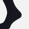 View 4 of product A single navy mid-length sock by Turnbull & Asser, crafted from organic cotton with a ribbed texture, stands upright on a white background.