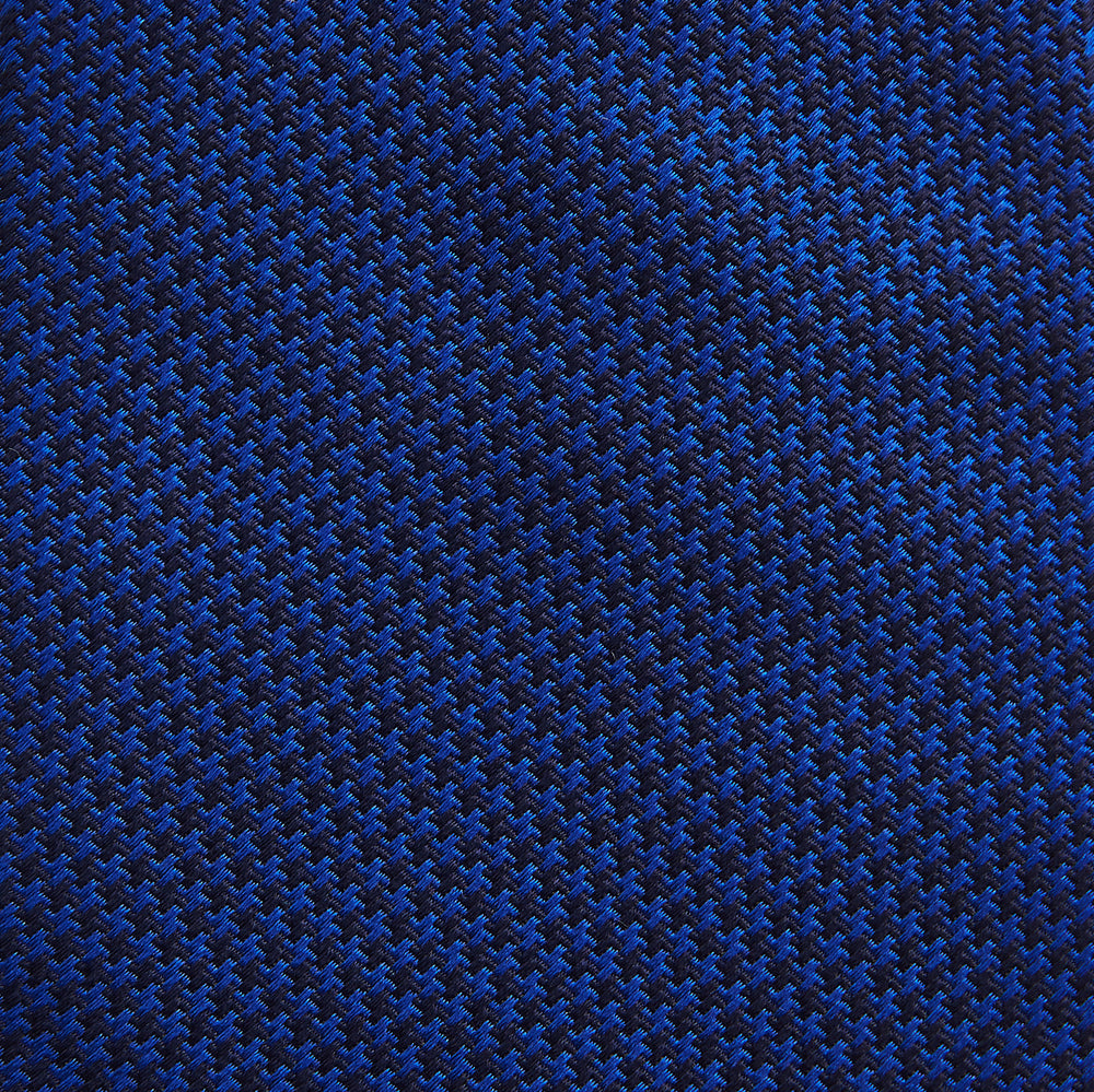 The HOUNDSTOOTH NAVY CRUISE TIE by Turnbull & Asser, featuring a textured blue design, is displayed rolled-up on a plain white background—an essential accessory for elevating formal looks.
