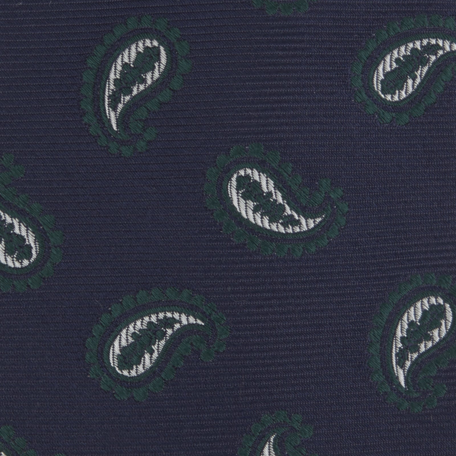 View 4 of product The Turnbull & Asser Navy and Forest Green Floating Paisley Silk Tie features a green and white paisley pattern, elegantly rolled up for a stylish presentation.