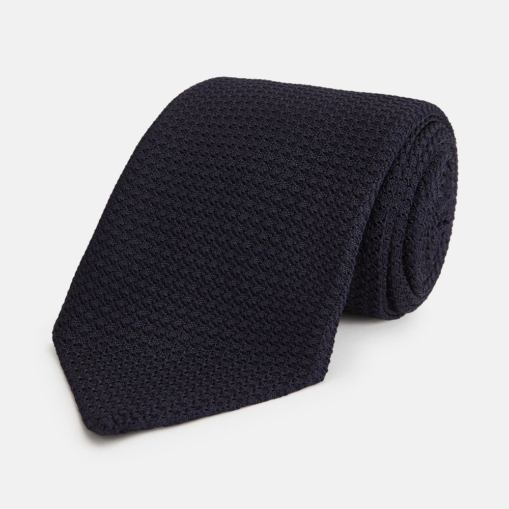 The Turnbull & Asser Midnight Blue Knitted Tie, elegantly textured and displayed on a white background, is a versatile addition to any gentleman's wardrobe.