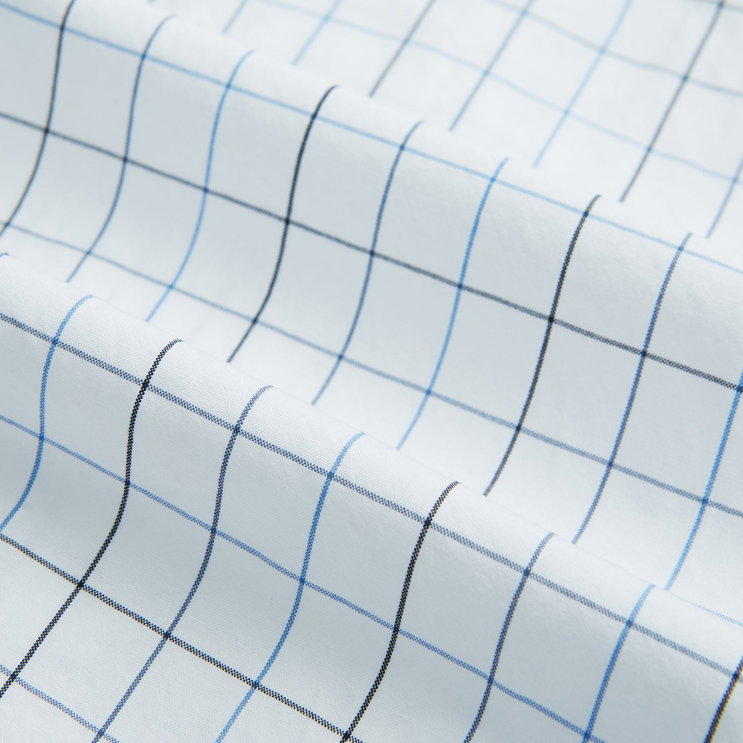 View 6 of product The Blue Grid Check Mayfair Shirt by Turnbull & Asser is a long-sleeve, button-up shirt with a T&A collar, crafted from organic cotton in a light and dark blue grid pattern, shown flat against a white background.