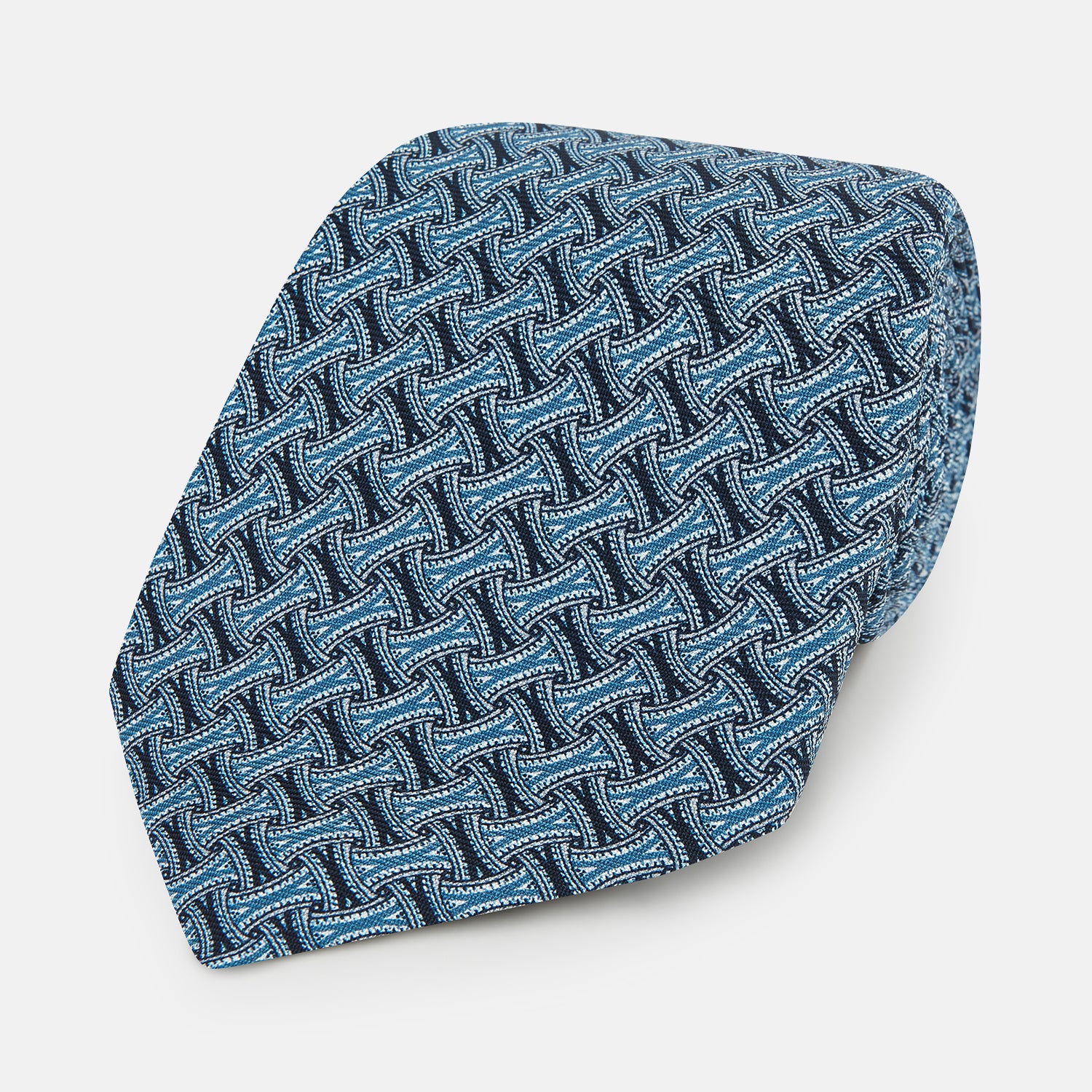 View 1 of product A close-up of the Turnbull & Asser Pale Blue and Navy Weave Patterned Silk Tie, featuring a textured geometric design. The silk tie is rolled at one end and displayed on a white background.