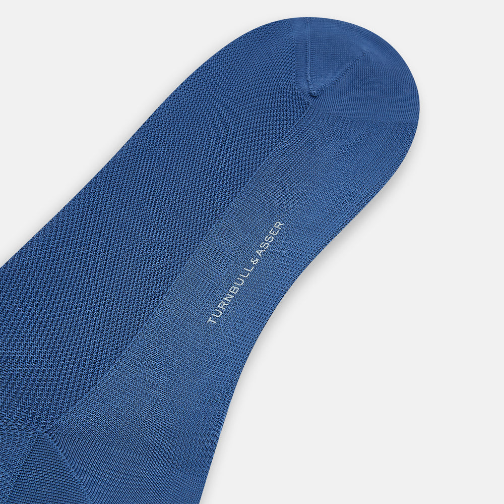 The Azzurro Micro Knit Mid-Length Sock by Turnbull & Asser, crafted from mercerised Egyptian cotton, is shown upright on a light background with a smooth texture, micro knit pattern, and slightly ribbed top band.