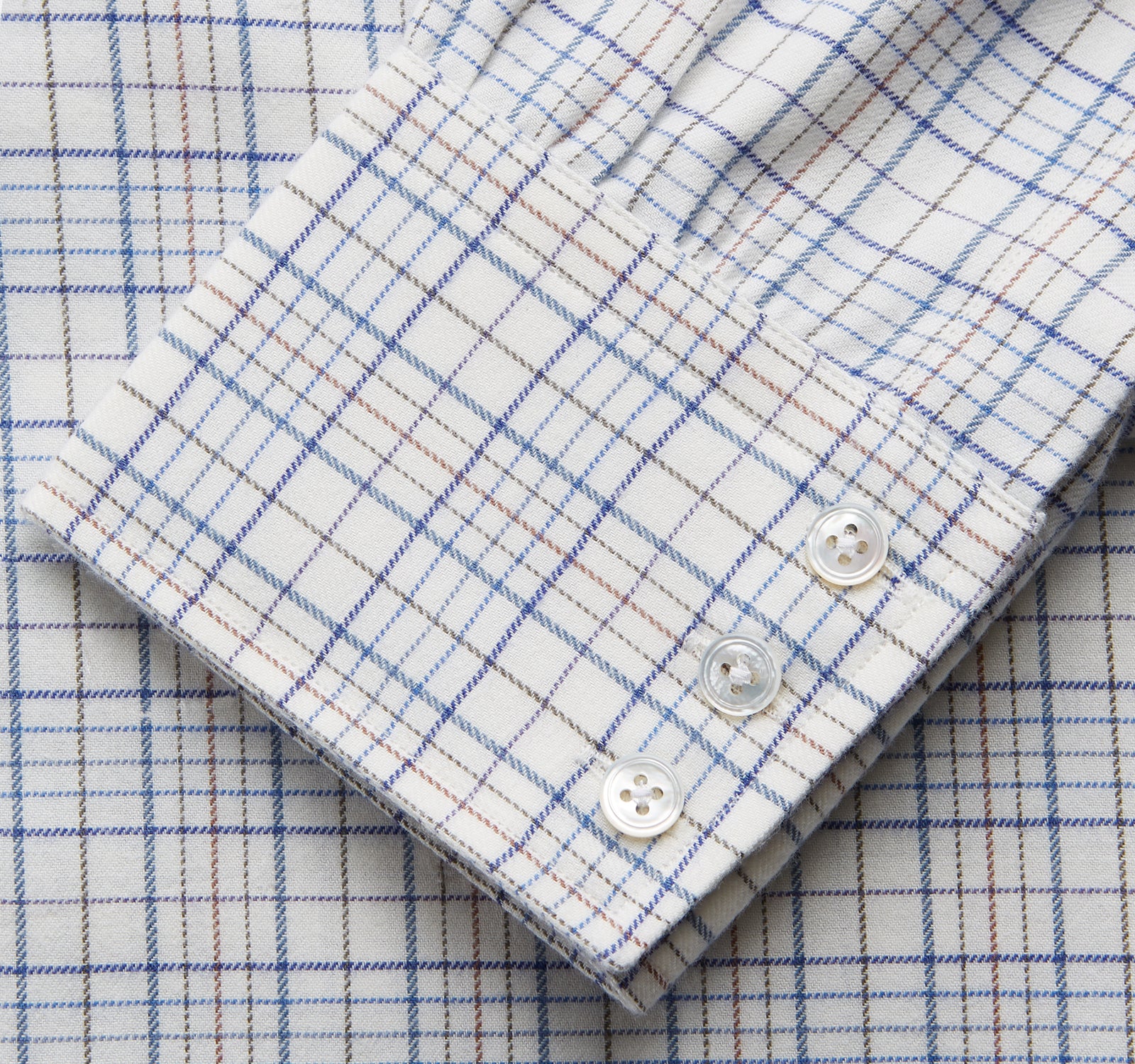 View 3 of product The Turnbull & Asser Blue Multi Check Regular Fit Cotton-Cashmere Shirt features a T&A collar, 3 button cuffs, and a white background with tonal blue and light brown checks—shown flat against a white background.
