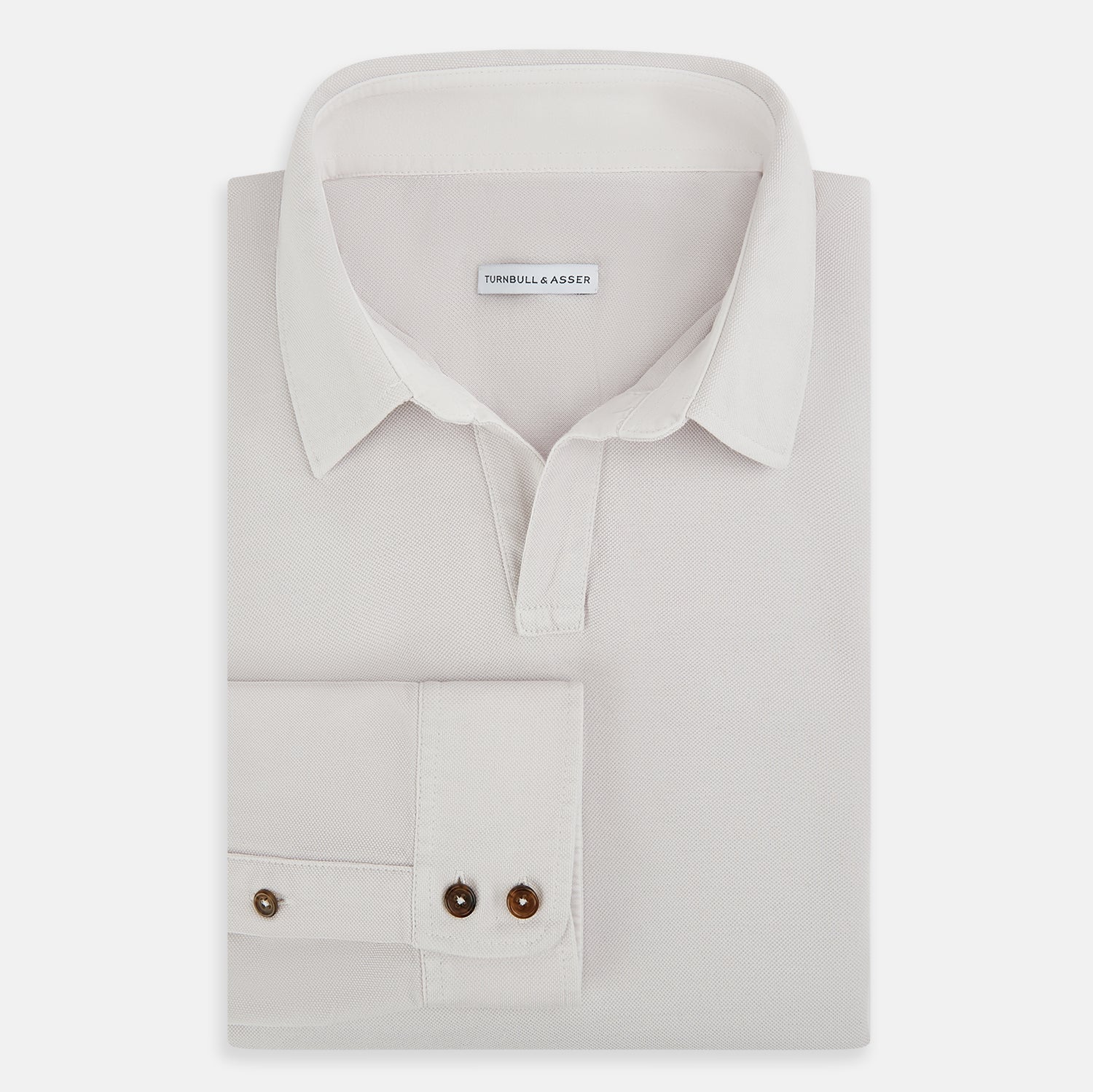 View 5 of product A pale pink luxury cotton rugby polo shirt by Turnbull & Asser, featuring long sleeves and a collar with no buttons, displayed flat on a white background.