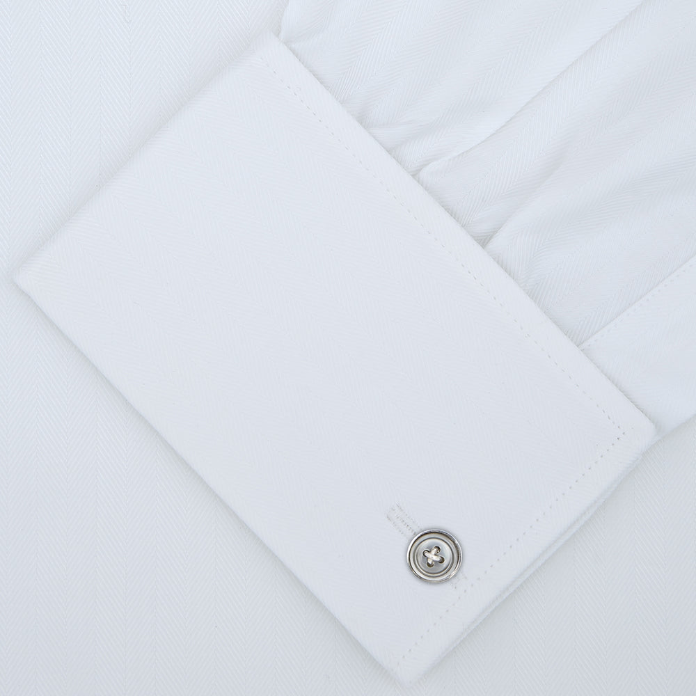 A White Self-On-Self Herringbone Sea Island Quality Cotton Shirt with Regent collar and double cuffs by Turnbull & Asser, displayed against a light gray background.