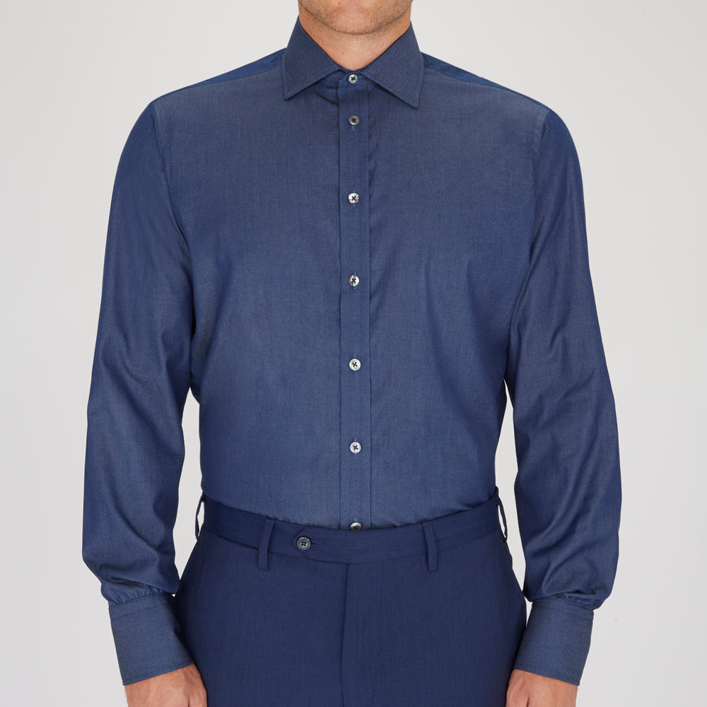 The Turnbull & Asser Dark Blue Denim-Cashmere Shirt features a Regent collar, long sleeves, and 3-button cuffs, neatly folded and displayed on a plain light background.