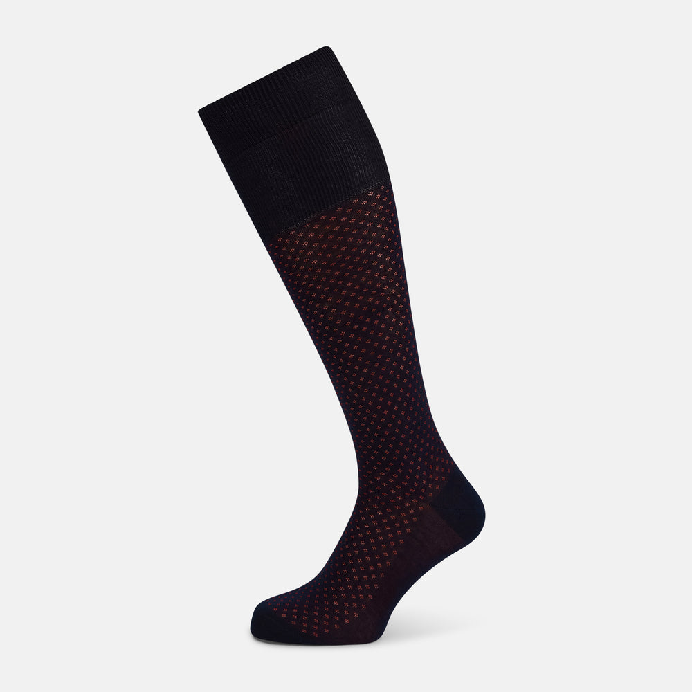 The Turnbull & Asser Navy/Red Motif Long Sock is crafted from mercerised Egyptian cotton, featuring a subtle red and navy diamond pattern with a solid navy cuff, heel, and toe, displayed on a white background.