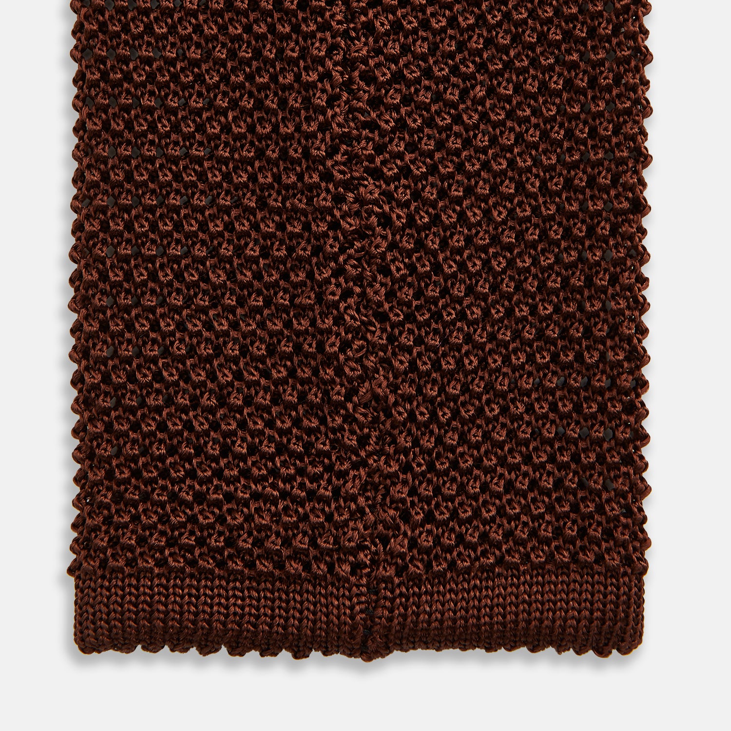 View 4 of product The Turnbull & Asser KNITTED BROWN SILK PLAIN TIE—a stylish, textured accessory—appears rolled up on a white background, perfect for elevating smart outfits.