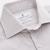 View 2 of product The Turnbull & Asser Sandstone Multi Stripe Cotton Tailored Fit Shelton Shirt features subtle vertical stripes, a pointed collar, and long sleeves, shown flat on a plain white background.