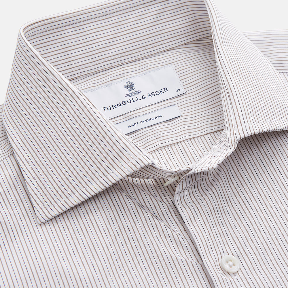 The Turnbull & Asser Sandstone Multi Stripe Cotton Tailored Fit Shelton Shirt features subtle vertical stripes, a pointed collar, and long sleeves, shown flat on a plain white background.