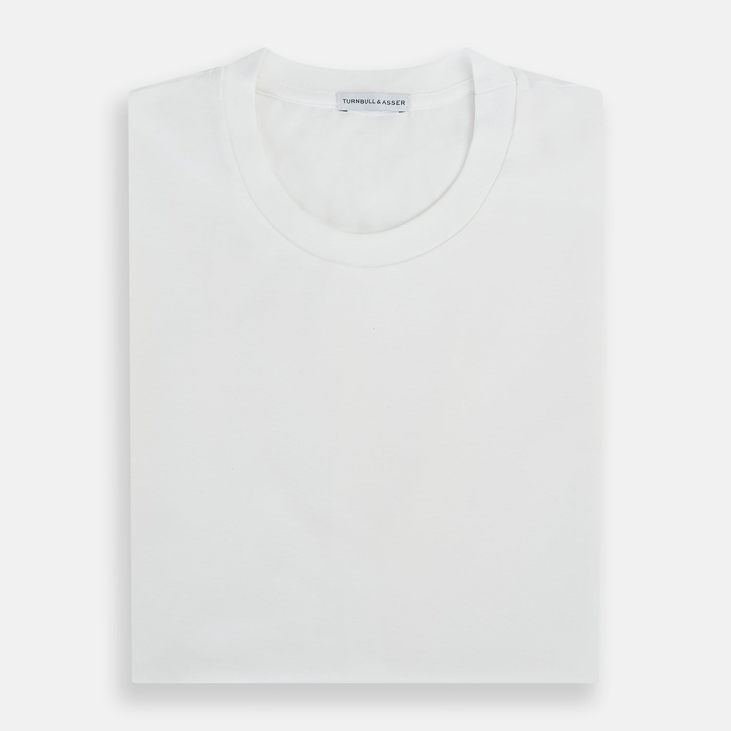 View 5 of product Experience comfort in the Turnbull & Asser White Short-sleeve Pyjama Shirt—a plain crew neck T-shirt laid flat on a white background, perfect as elevated loungewear or a sleek pyjama essential.