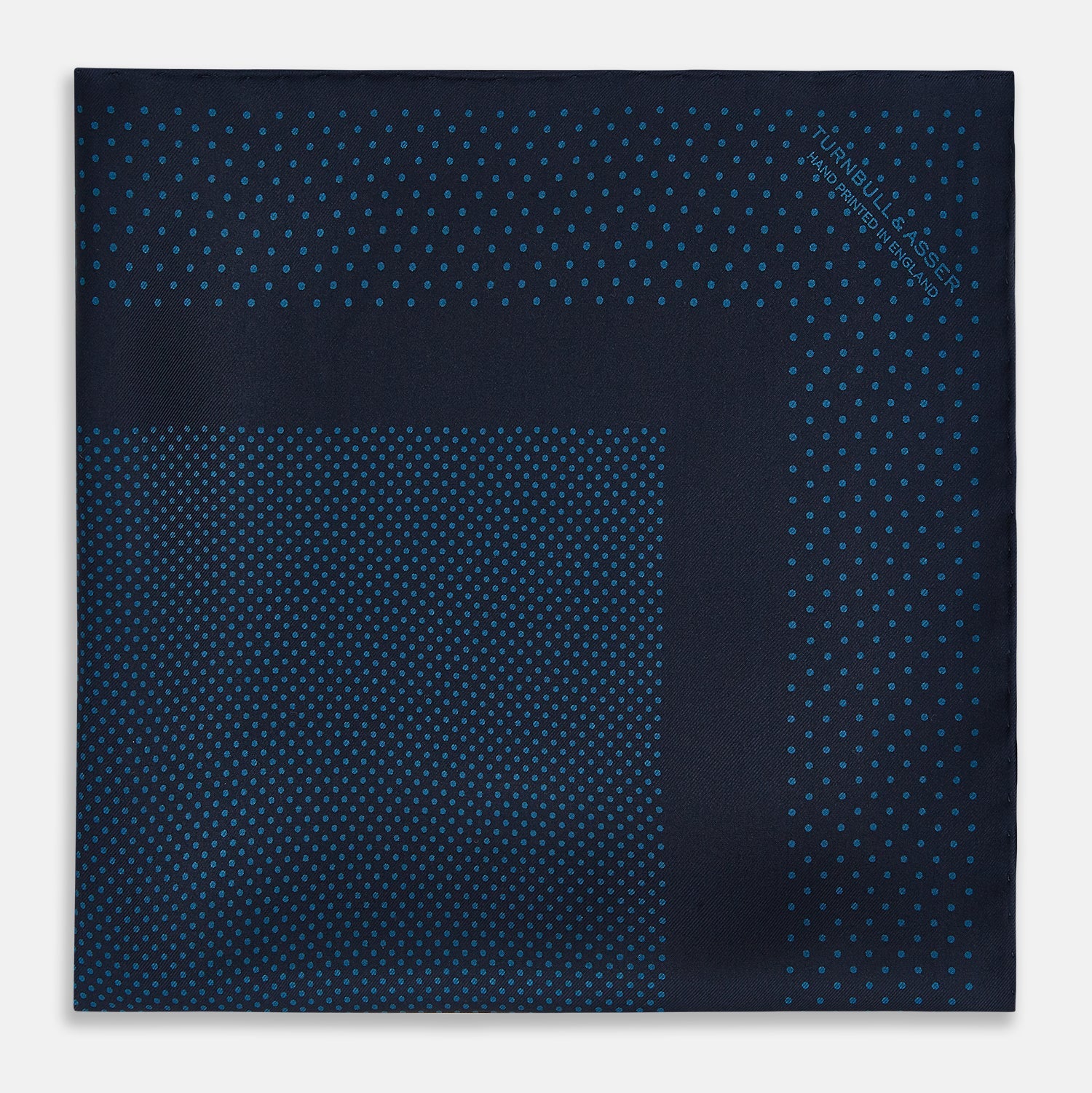 View 3 of product The Turnbull & Asser Navy and Blue Dot Silk Pocket Square features a handmade design in navy silk with small light blue dots and a crisp border, finished with one corner folded to display the reverse side.