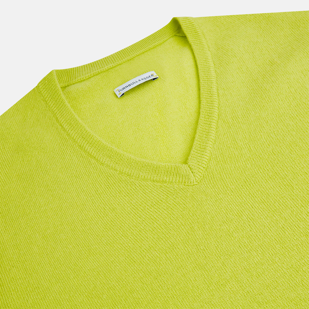 The Lemon Green Cashmere V-neck Jumper by Turnbull & Asser features ribbed cuffs and hem—an essential long sleeve knitwear piece, shown against a white background.