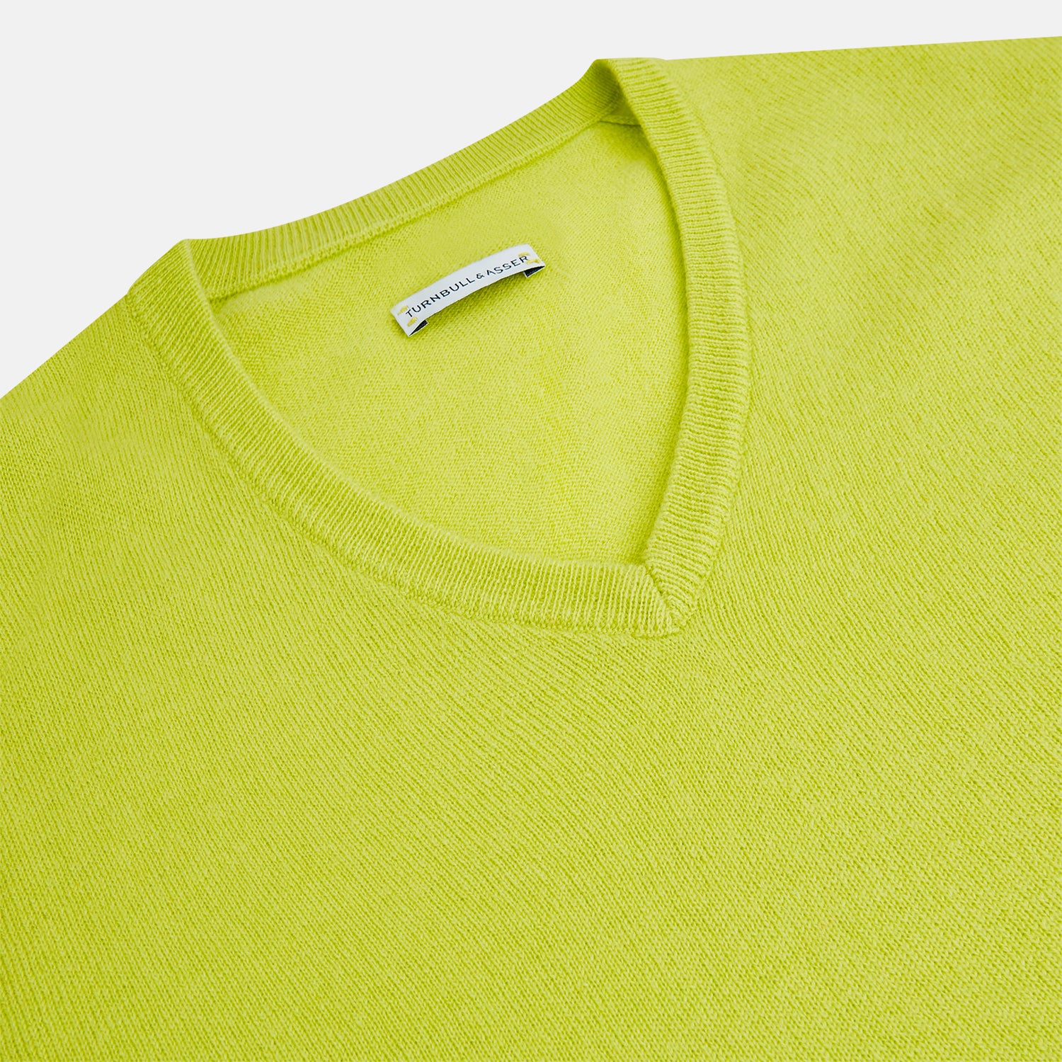 View 2 of product The Lemon Green Cashmere V-neck Jumper by Turnbull & Asser features ribbed cuffs and hem—an essential long sleeve knitwear piece, shown against a white background.