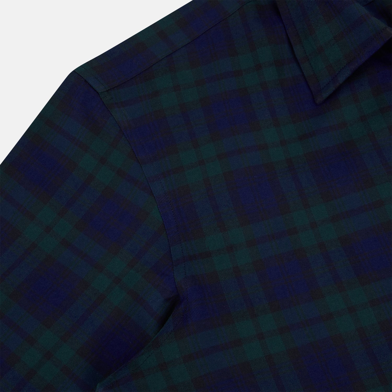 View 6 of product The Turnbull & Asser Black Watch Tartan Windsor Shirt is a long-sleeve, button-up shirt with a dark green and navy tartan pattern, white buttons, collar, and curved hem—showcasing British craftsmanship on a plain white background.