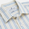 View 3 of product A man with short brown hair stands against a beige background in a Turnbull & Asser Blue and Off-White Stripe Cotton Weekend Fit Finch Shirt, featuring vertical stripes and a Derby collar, paired with dark pants. One hand is in his pocket; he has a neutral expression.